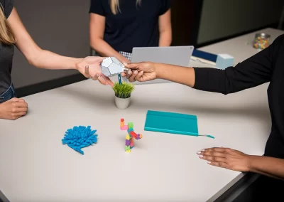 overhead view of team member handing branded fidget toy to another team member over table